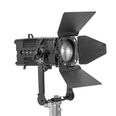 Astera Pluto Fresnel front side angle view showing fresnel lens with barndoors, control buttons, ventilation, yoke mount and stand adapter, white background