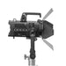 Astera Pluto Fresnel rear side view showing numbered control buttons, zoom knob, ventilation grille, barndoors, yoke mount and stand adapter, white background