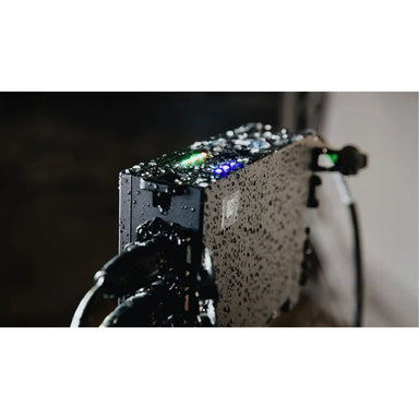 Astera QuikBeam NetBox in use outdoors covered in water droplets demonstrating IP65 waterproof rating close up of control panel with LEDs lit