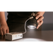 Astera SolaBulb in use hand holding bulb emitting warm white light beam onto surface connected to Astera PowerStation controller lifestyle shot