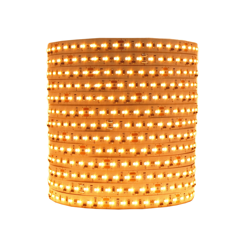 Moss LED FlexLED Bi-Colour 24V LED strip coiled reel lit in dim warm white showing flexible PCB with warm and cool white LEDs on white background