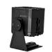 Astera PB15 PixelBrick side rear angle view showing black compact LED light housing with battery compartment safety label tilt adjustment knob and mounting bracket base plate for professional wireless film and event lighting on transparent background