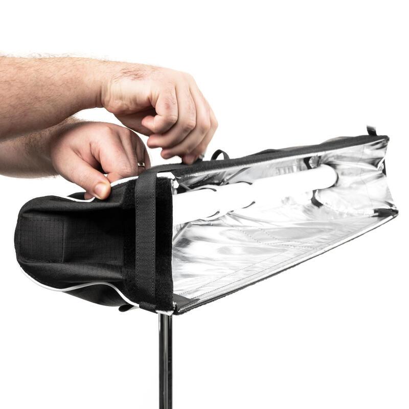 Astera SNAPBAG softbox being folded and collapsed by hand showing quick setup and teardown design on light stand