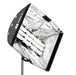 Astera softbox adapter SBAAT22 front angle view showing multiple Titan LED tube lights mounted inside open silver reflective softbox with Astera SnapLock branding black fabric exterior chrome light stand for professional film and photography lighting on white background