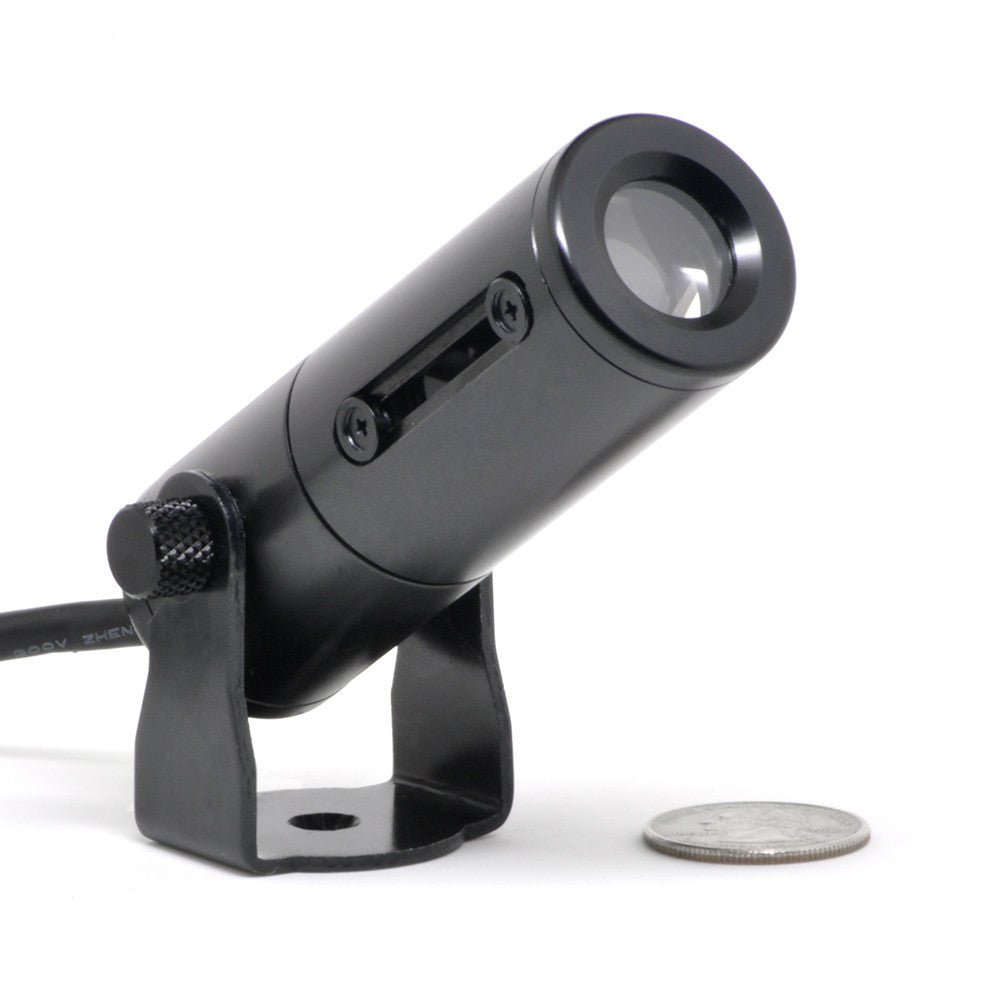 Gantom iQx micro image projector close-up front view with coin for size comparison showing compact black cylindrical design with lens
