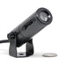 Gantom iQx micro image projector close-up front view with coin for size comparison showing compact black cylindrical design with lens