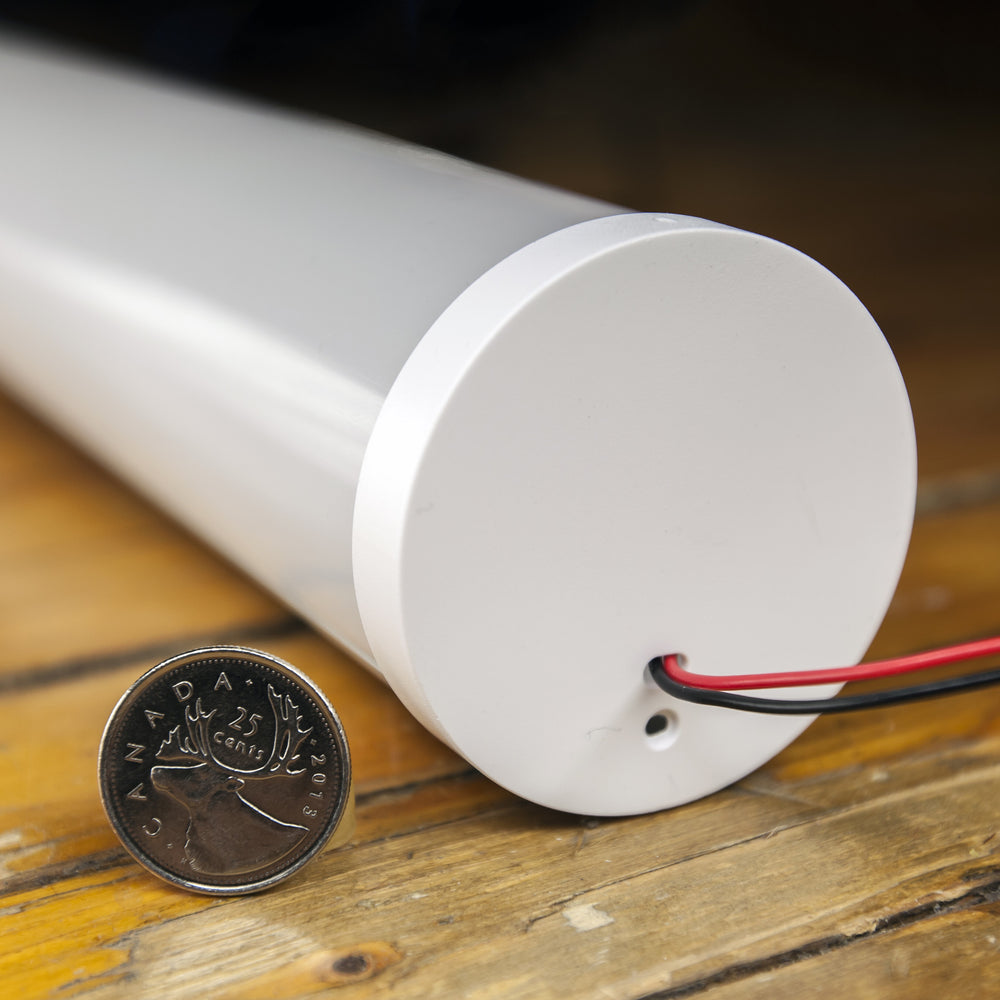 Moss LED aluminum channel O6060C close-up of end cap installed with wire exit hole and coin for size reference on wood surface