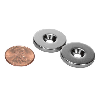 Moss LED high powered neodymium countersunk ring magnets N52 grade pair showing north and south pole nickel plated with penny for size reference 7/8 inch diameter