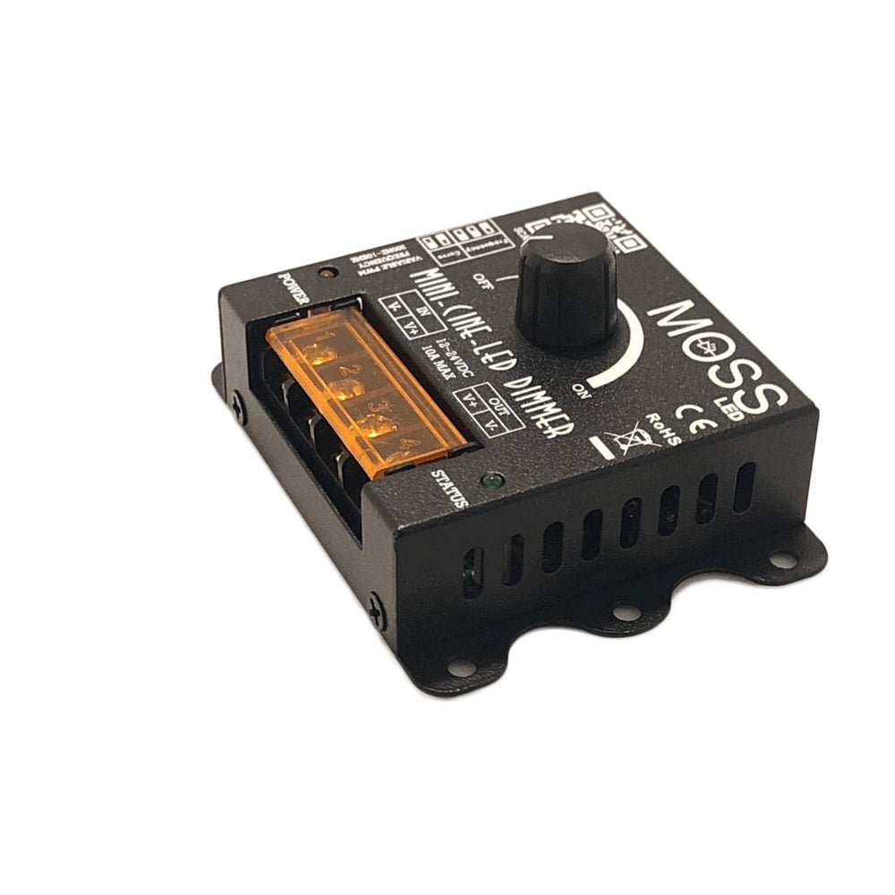 Moss LED Mini-Cine single channel rotary dimmer V2 elevated angle view showing mounting feet CE RoHS markings orange terminal block and ventilation slots on white background