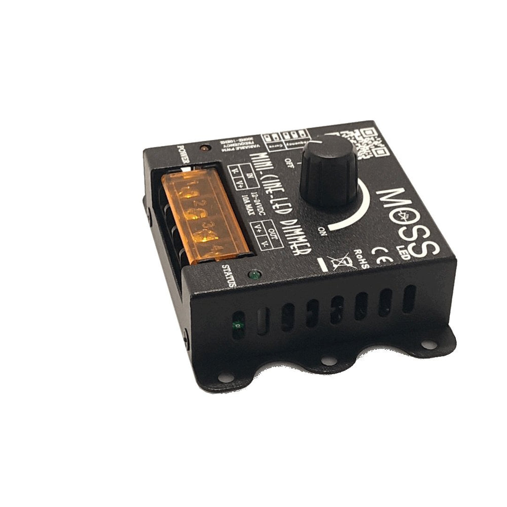 Moss LED Mini-Cine single channel rotary dimmer V2 left side view showing DC barrel jack power connector orange terminal block and green status LED on black metal enclosure